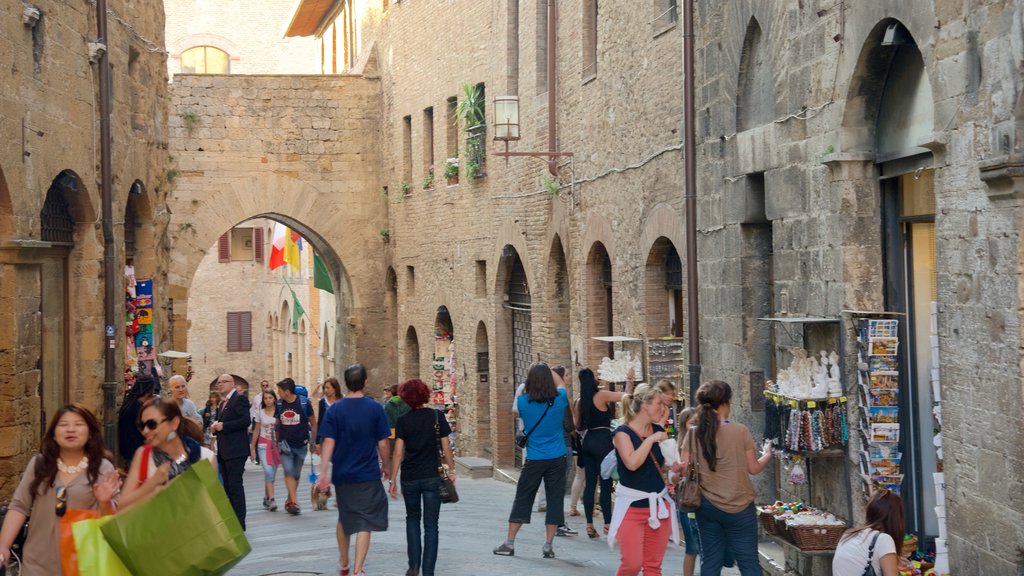 San Gimignano featuring heritage architecture as well as a large group of people