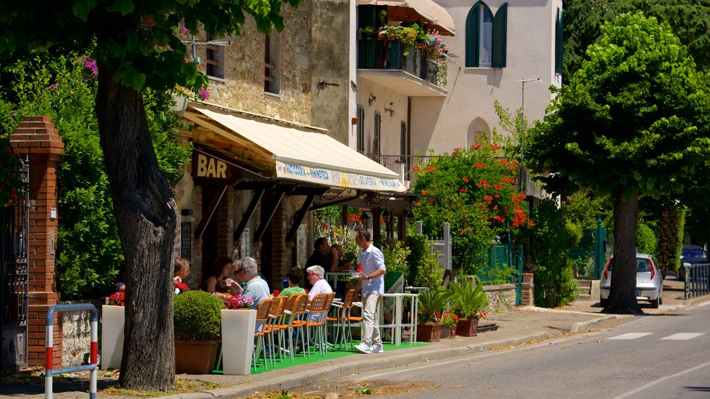 Passignano sul Trasimeno ofreciendo comidas al aire libre, ambiente de cafetería y una localidad costera