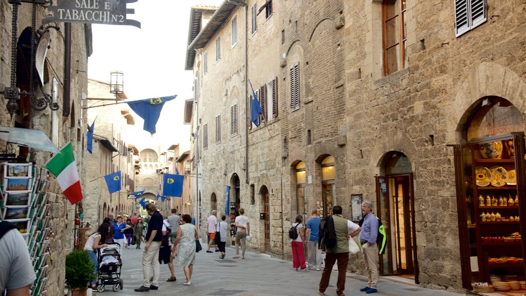 San Gimignano ofreciendo compras y escenas urbanas y también un gran grupo de personas