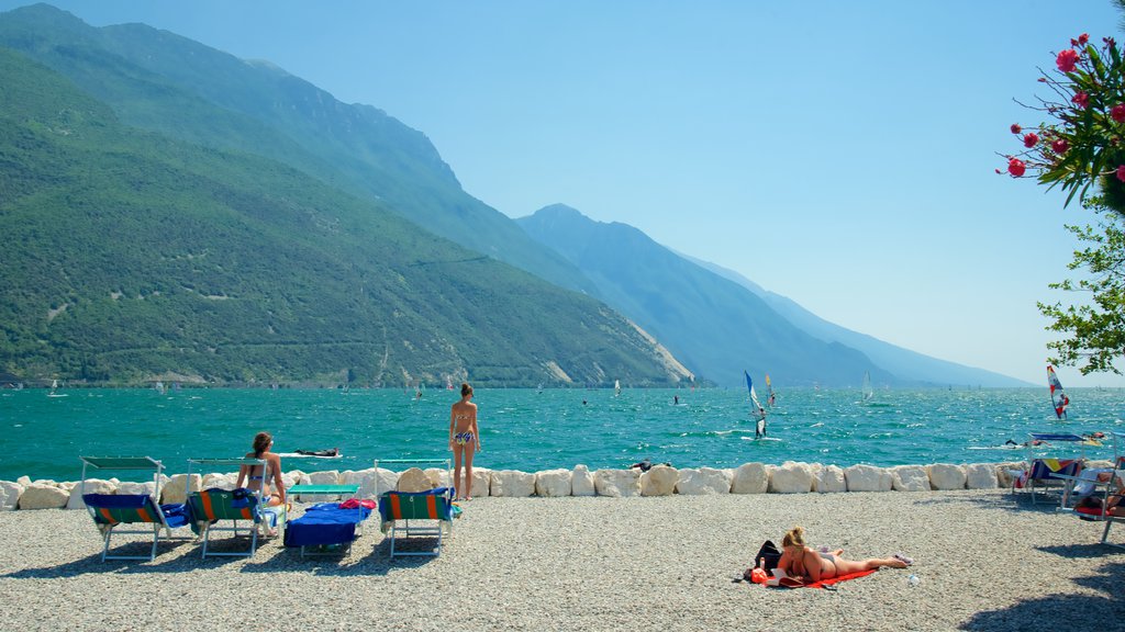 Nago-Torbole showing windsurfing, a pebble beach and mountains