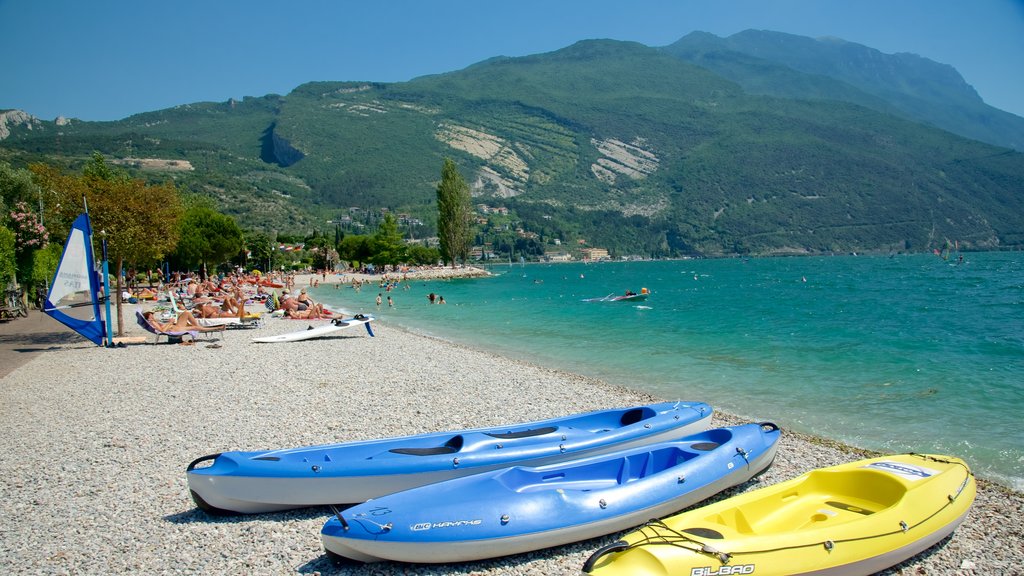 Nago-Torbole que incluye vista general a la costa, una playa de piedras y kayaks o canoas