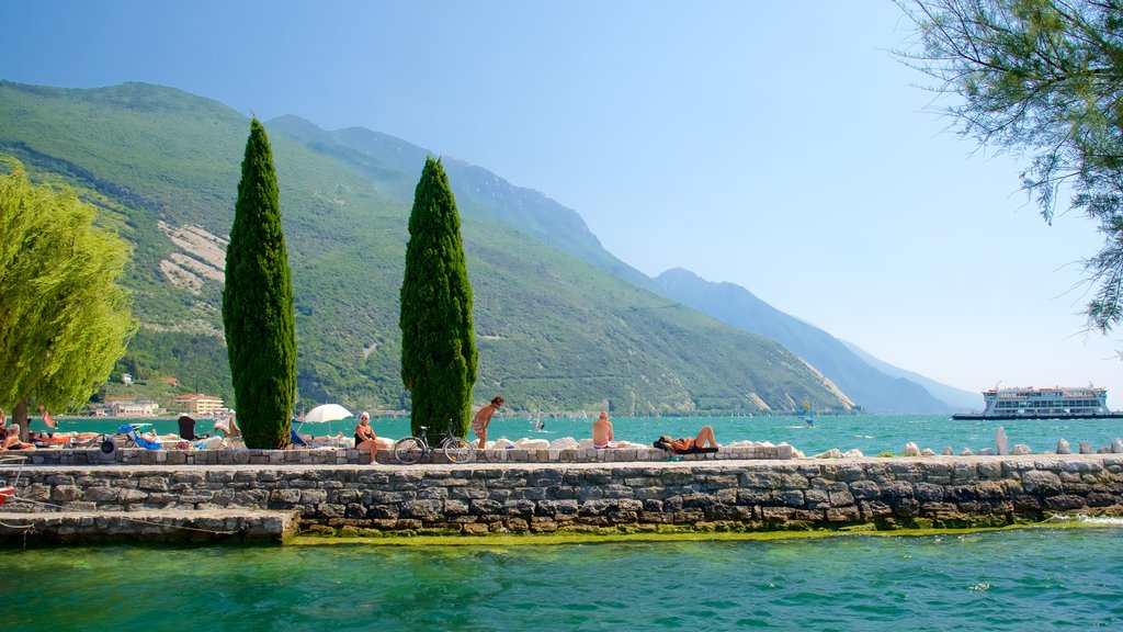 Nago-Torbole featuring general coastal views and boating as well as a small group of people