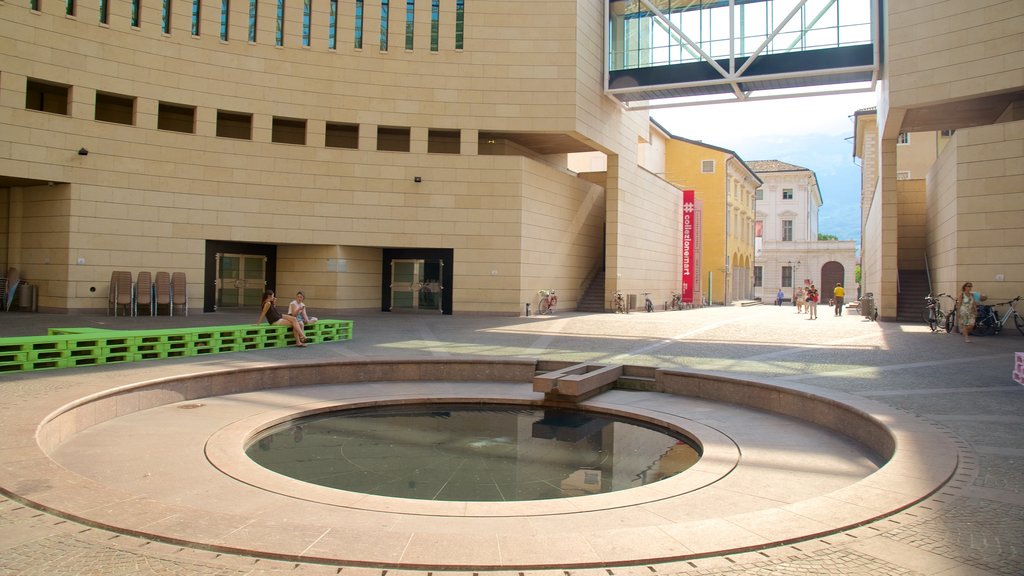 Museum of Modern and Contemporary Art showing a pond and modern architecture as well as a small group of people