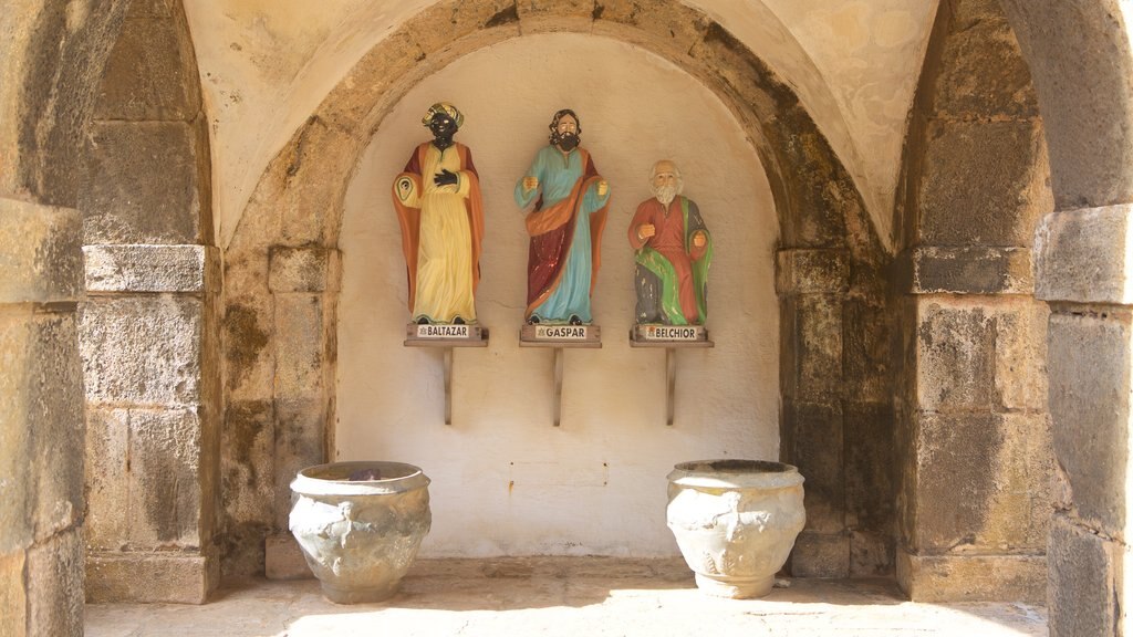 Castillo de los Tres Reyes mostrando una estatua o escultura, elementos patrimoniales y elementos religiosos