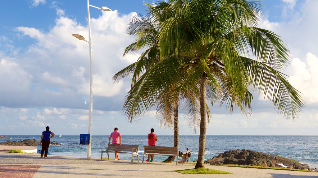 Praia do Porto da Barra que inclui paisagens litorâneas assim como um pequeno grupo de pessoas