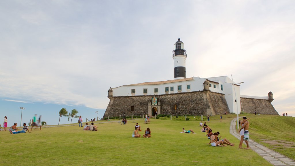 Playa Farol da Barra que incluye un faro y vistas generales de la costa y también un gran grupo de personas