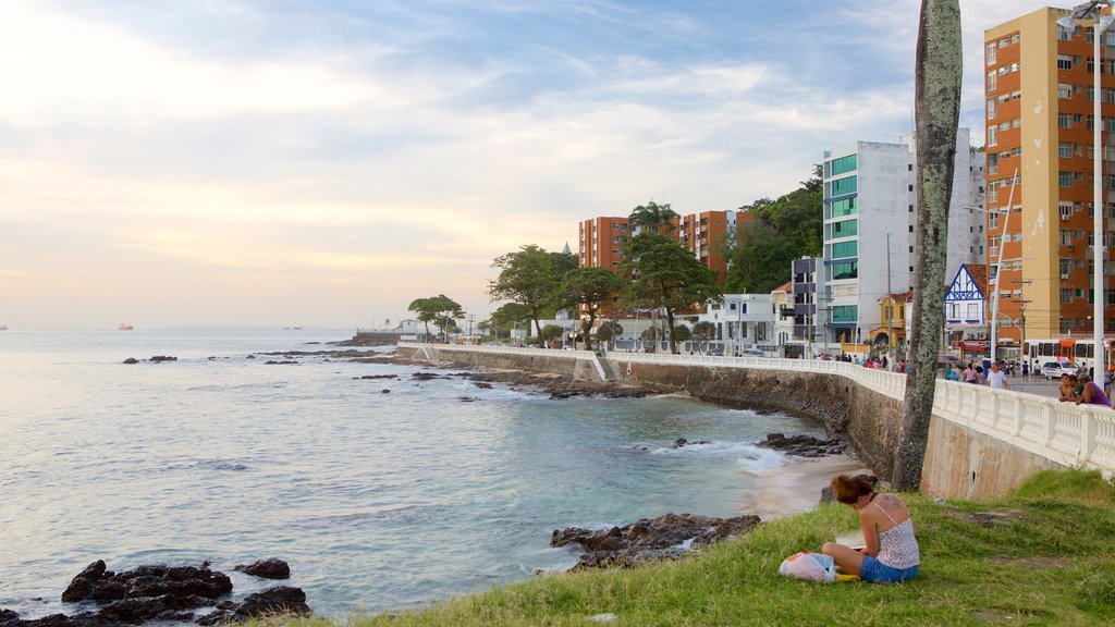 Playa Farol da Barra mostrando vistas generales de la costa y una ciudad costera y también una mujer