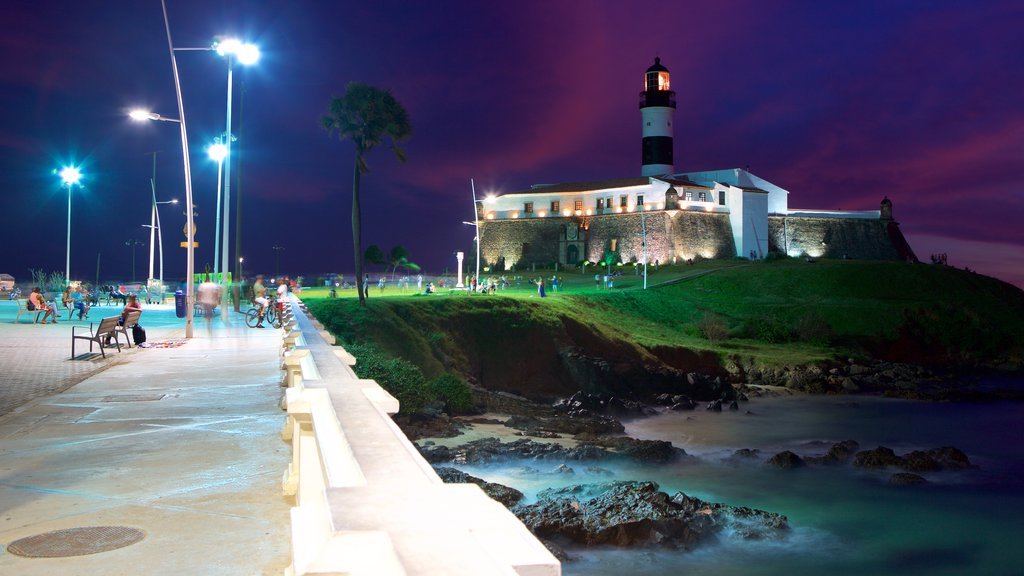 Farol da Barra Beach which includes night scenes, general coastal views and a lighthouse