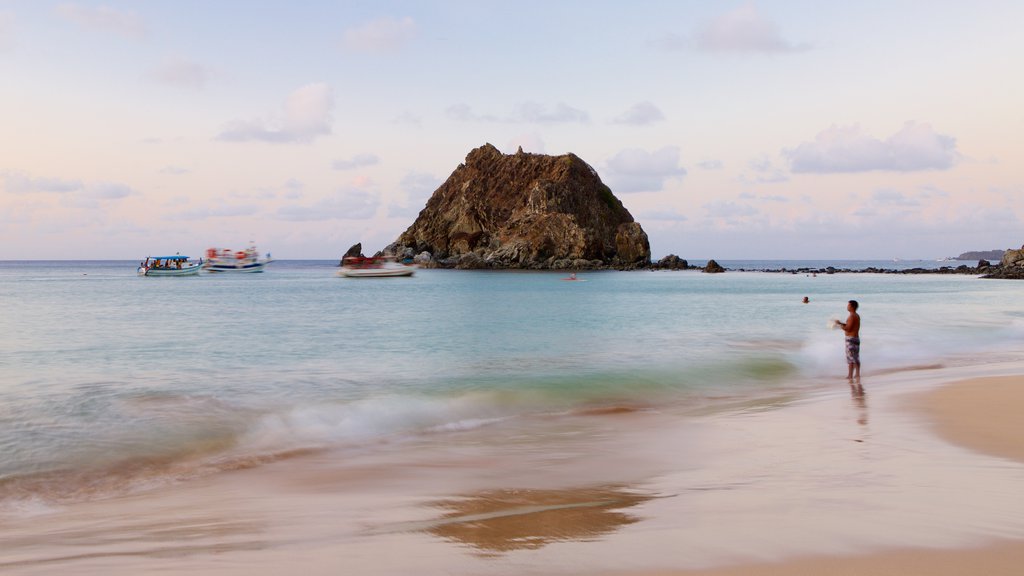 Playa de Conceicao que incluye vistas generales de la costa y una playa de arena y también un hombre