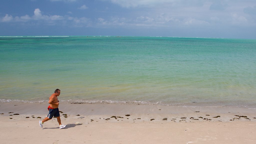 Ponta Verde-stranden som inkluderer kyst og sandstrand i tillegg til en mann