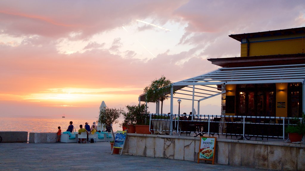 Piran que inclui uma cidade litorânea, um pôr do sol e cenas de cafeteria