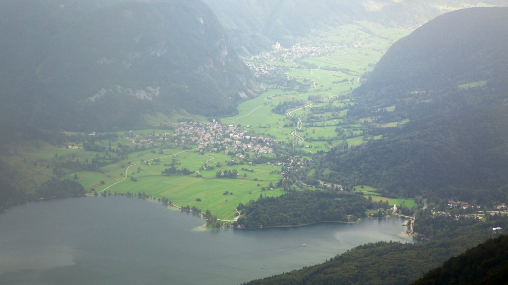 Triglav National Park which includes a small town or village, mist or fog and a lake or waterhole