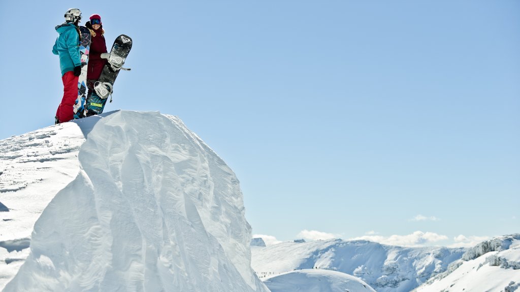 Estação de esqui Cerro Chapelco que inclui neve e snowboard assim como um casal