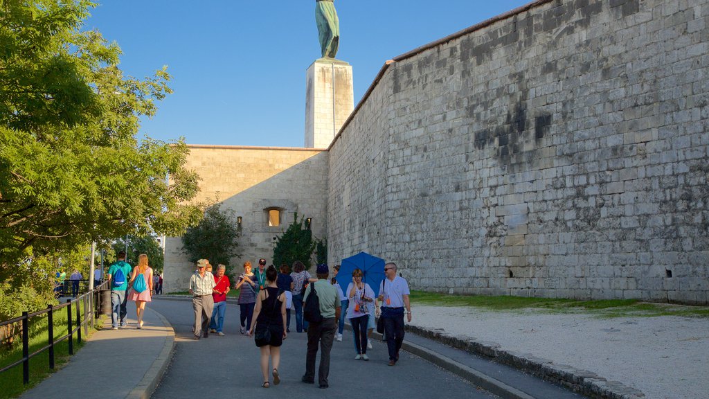 Liberty Statue showing a monument and heritage elements as well as a small group of people