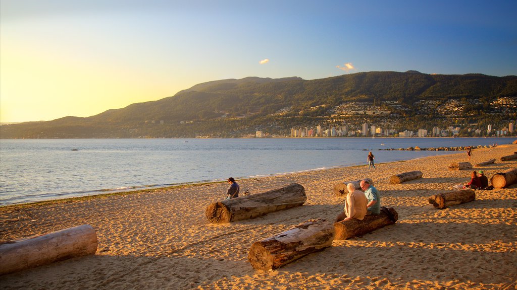 Stanley Park showing a sandy beach as well as a small group of people