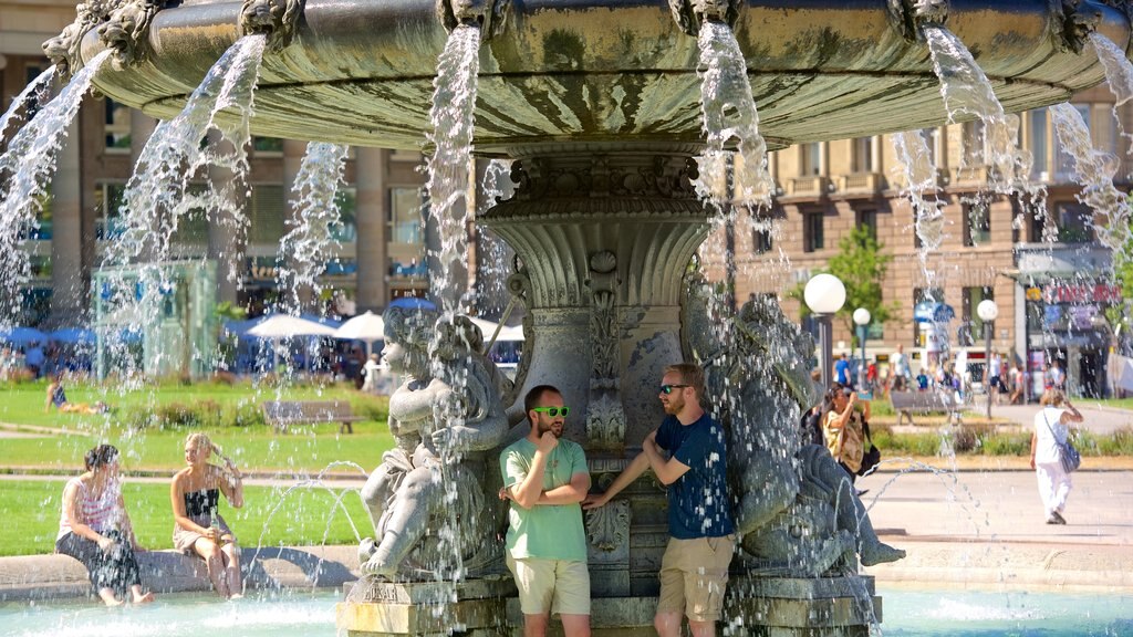 Schlossplatz caracterizando uma fonte assim como um pequeno grupo de pessoas