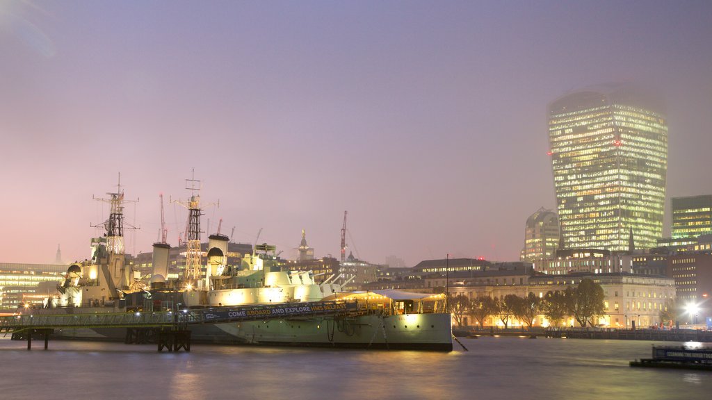 HMS Belfast joka esittää yökuvat, kaupunki ja joki tai puro