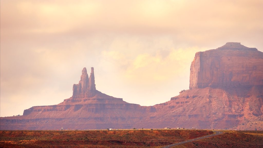 Monument Valley que incluye una puesta de sol, un barranco o cañón y escenas tranquilas