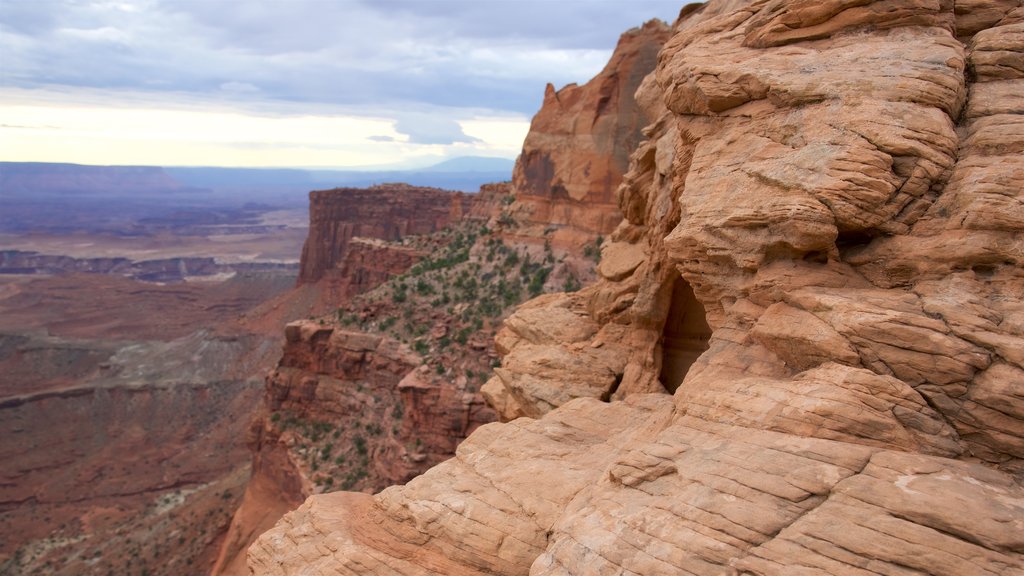 Mesa Arch Trail showing landscape views, mountains and a gorge or canyon