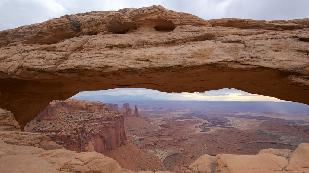 Mesa Arch Trail showing a gorge or canyon, landscape views and mountains