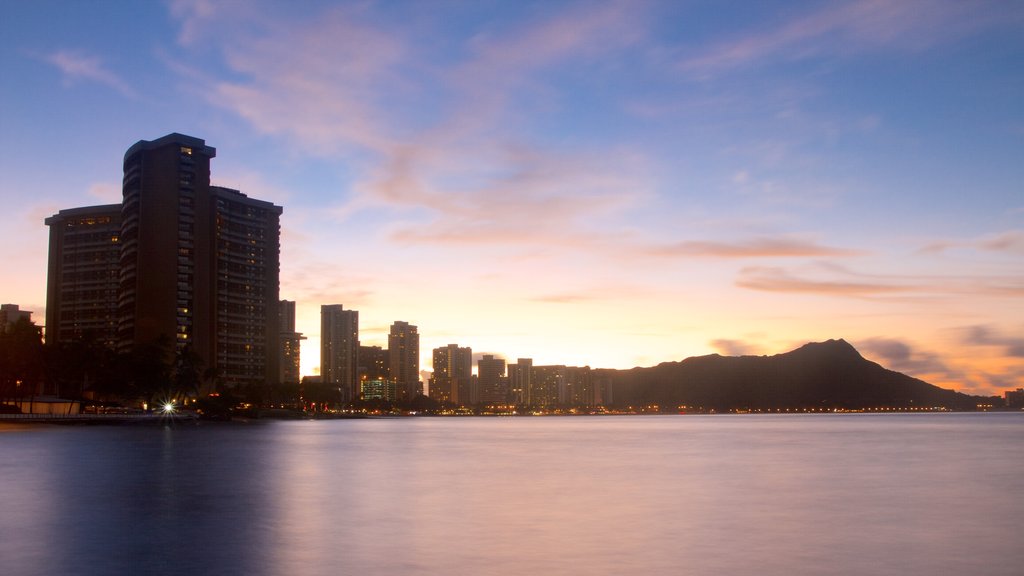 Waikiki Beach som viser en solnedgang, skyline og udsigt over kystområde