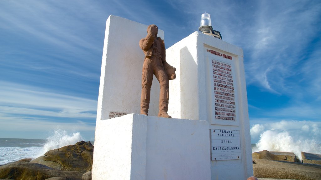 Punta del Diablo que incluye señalización, vistas generales de la costa y un monumento