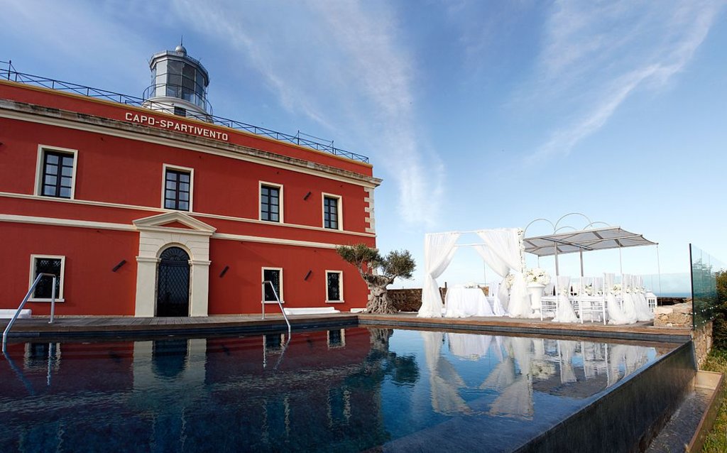 view of the pool and lighthouse building at Faro Capo Spartivento hotel, Sardinia