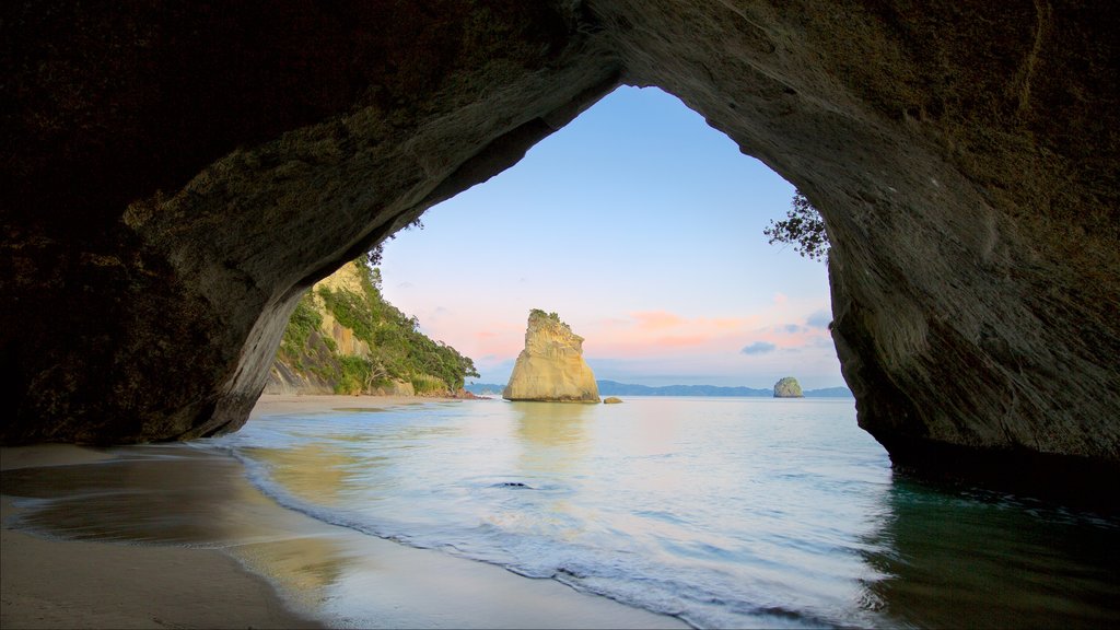 Cathedral Cove Beach mostrando una playa de arena, costa escarpada y cuevas