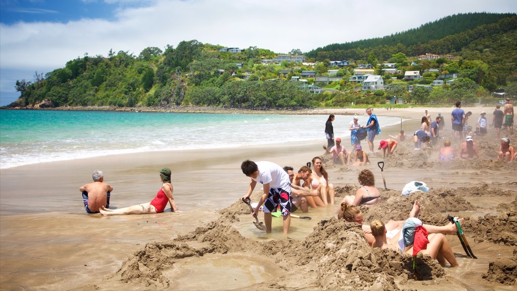 Hot Water Beach toont een kuststadje, zwemmen en een strand