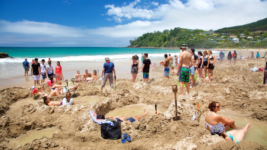 Hot Water Beach featuring a sandy beach and swimming as well as a large group of people