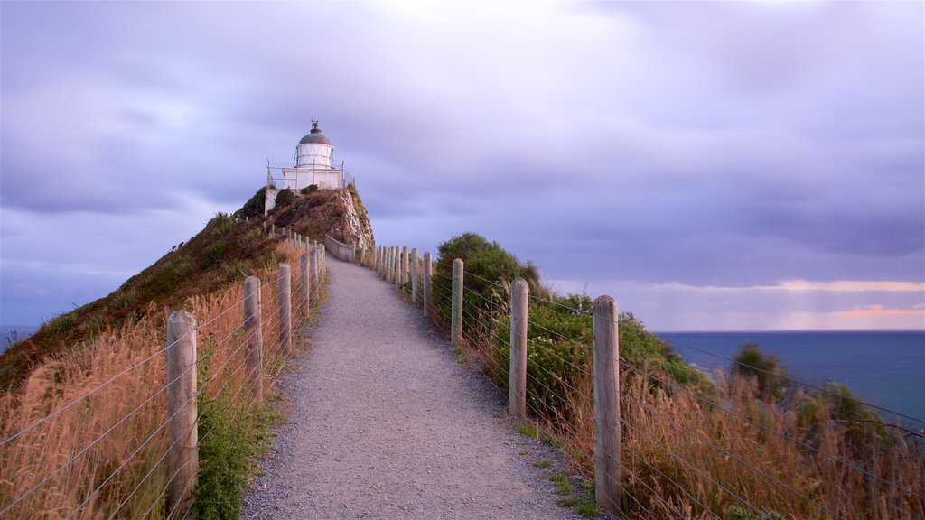 Nugget Point Lighthouse featuring a sunset, a bay or harbour and a lighthouse