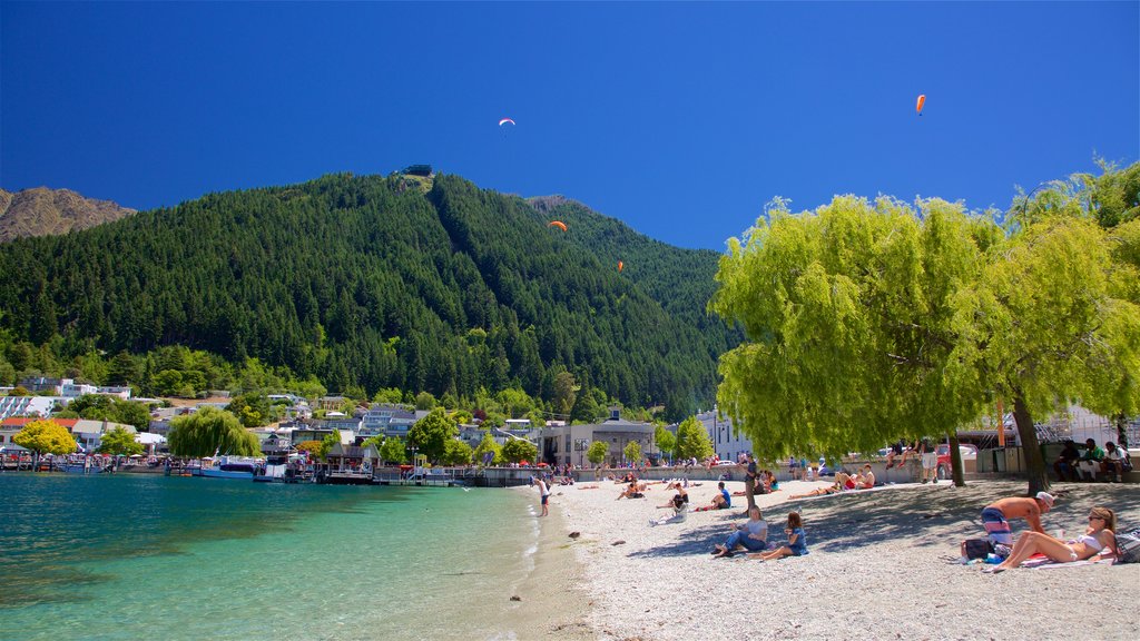 Playa de Queenstown mostrando un lago o abrevadero, una pequeña ciudad o pueblo y paracaidismo