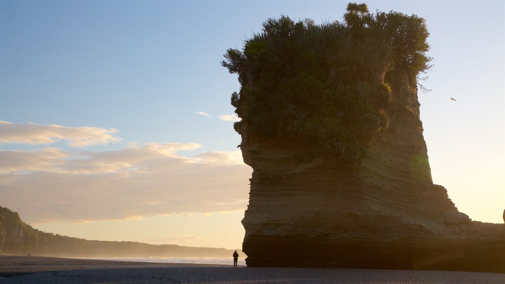 Punakaiki which includes a sunset, mist or fog and rugged coastline