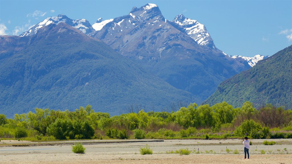 Glenorchy som viser skovområder, bjerge og en stenstrand