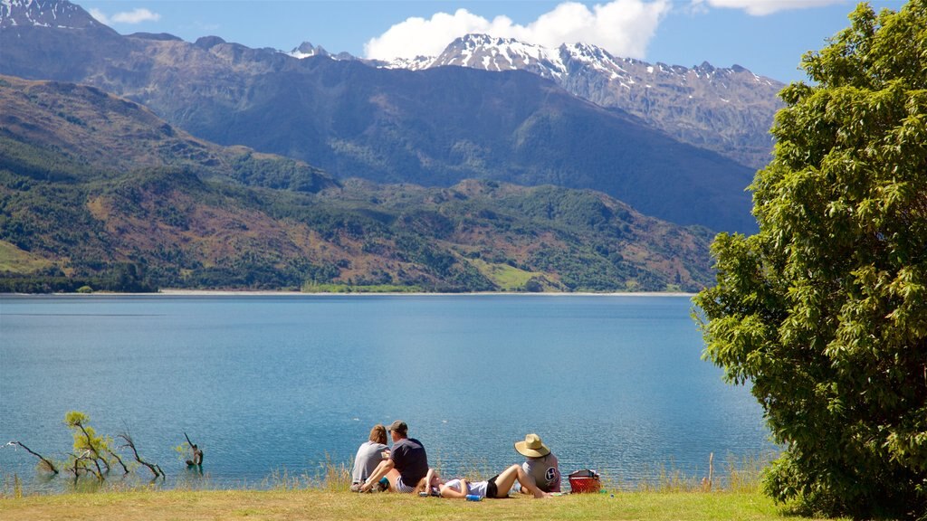 Wanaka showing a lake or waterhole and mountains as well as a small group of people