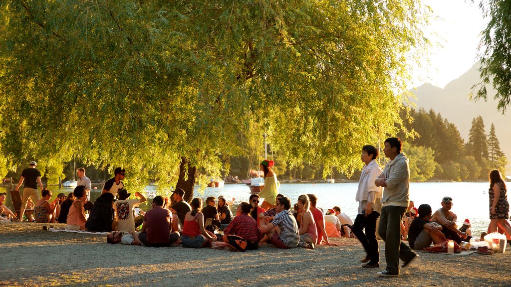 Queenstown Beach which includes a sunset, mountains and a lake or waterhole