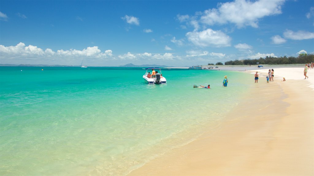 Great Keppel Beach welches beinhaltet Sandstrand und allgemeine Küstenansicht sowie kleine Menschengruppe