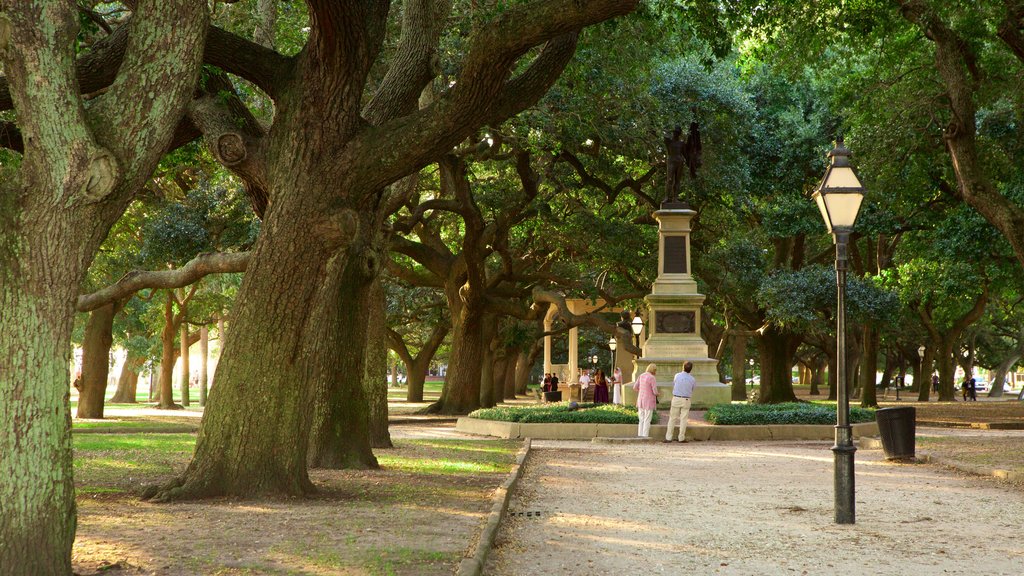 Charleston which includes a garden and a statue or sculpture as well as a couple