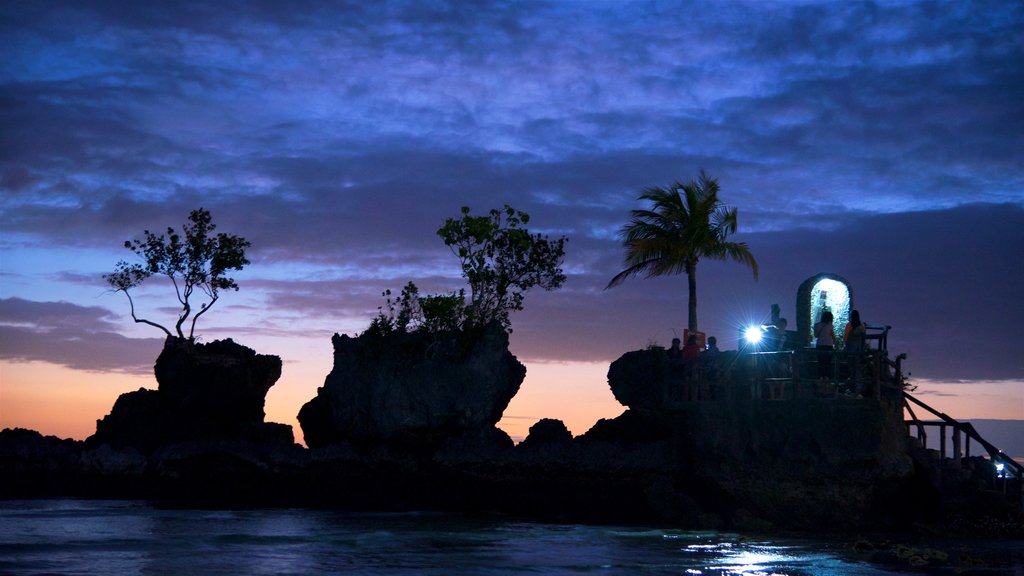 Roca de Willy ofreciendo escenas nocturnas, aspectos religiosos y costa escarpada