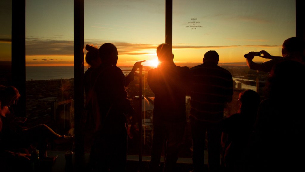 Eureka Tower featuring a sunset and views as well as a small group of people