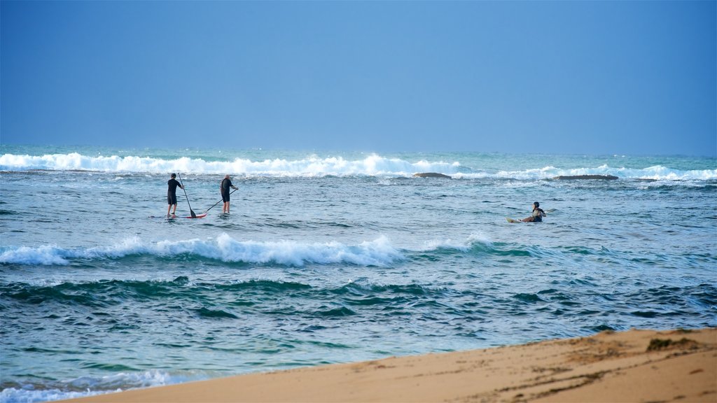 Blue Bay showing a sandy beach, waves and a bay or harbor