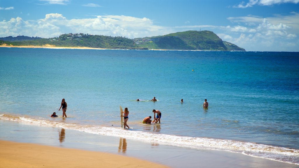 Terrigal which includes a bay or harbor and a sandy beach as well as a small group of people