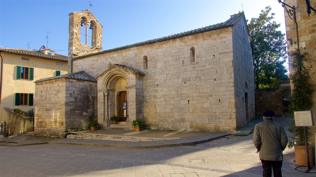 San Quirico d\'Orcia ofreciendo una iglesia o catedral y también un hombre