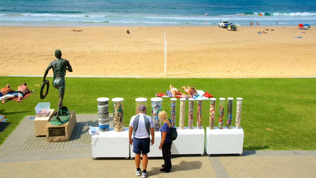 Wollongong North Beach showing outdoor art and a sandy beach as well as a couple