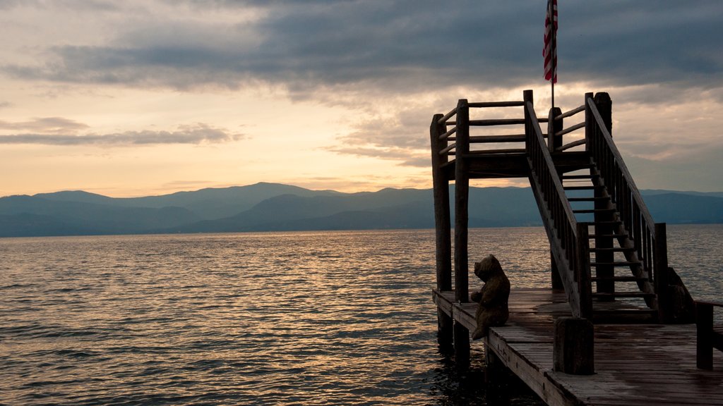 Bigfork featuring a lake or waterhole, mountains and a sunset