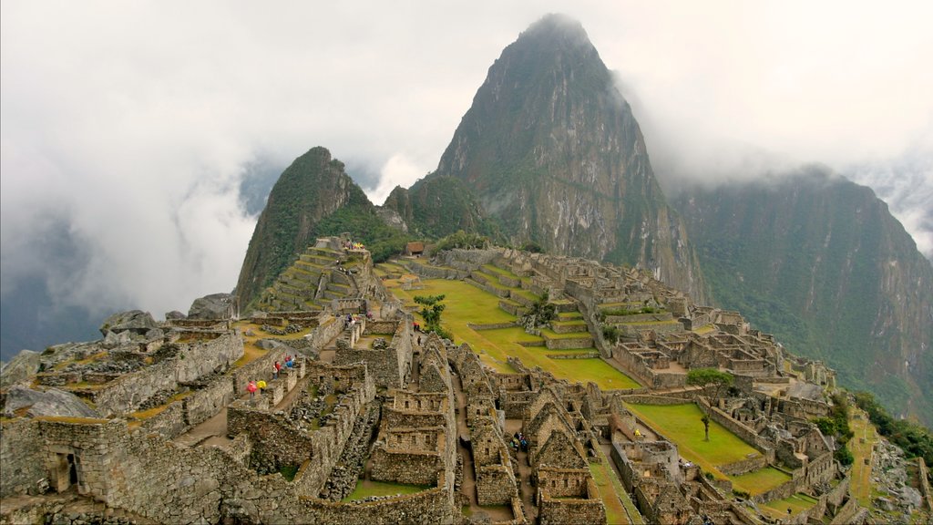 Huayna Picchu som inkluderar berg, historiska element och dimma