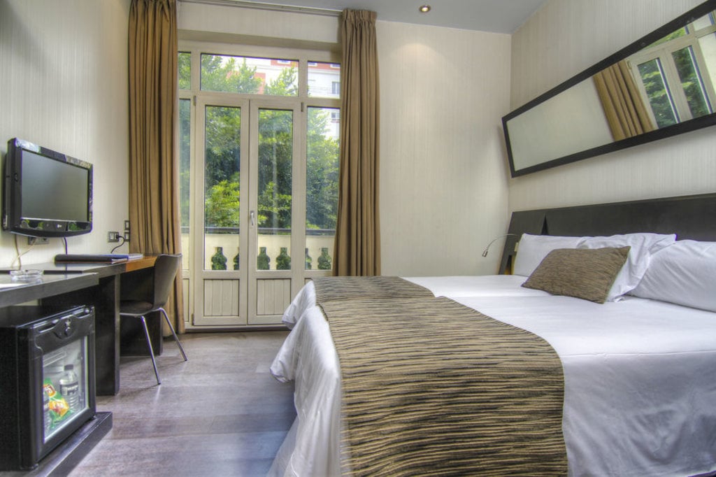 habitacion-hotel-derecha-cama-doble-izquierda-escitorio-televisor-al-fondo-balcon-con-vistas.jpg?1587640185