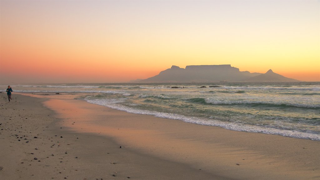 Bloubergstrand mostrando una puesta de sol, montañas y vistas generales de la costa