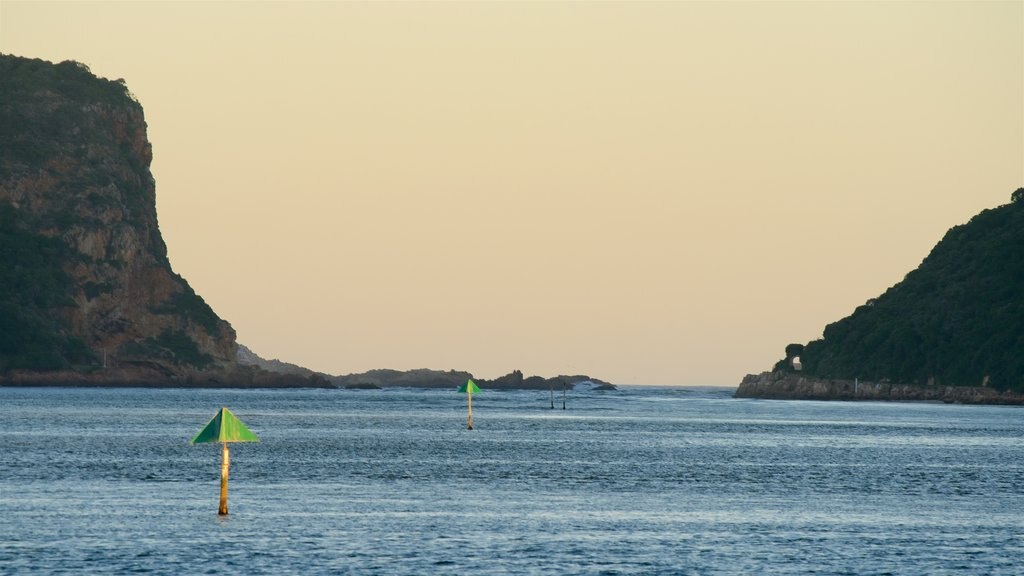 Knysna caracterizando paisagens litorâneas, um pôr do sol e litoral acidentado