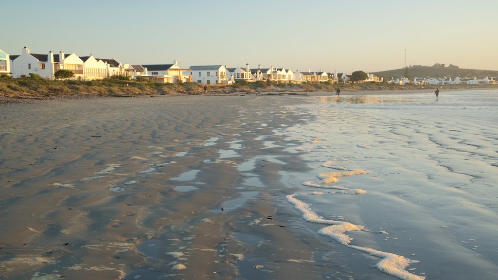 Playa de Paternoster mostrando un atardecer, una ciudad costera y una playa de arena